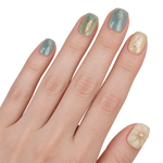 Faux ongles bleu gris et beige à fleurs et détails dorés portés sur une main — Donghun. @worn