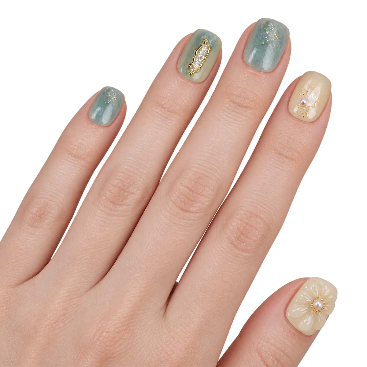 Faux ongles bleu gris et beige à fleurs et détails dorés portés sur une main — Donghun. @worn