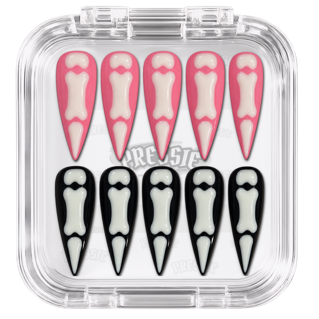 Faux ongles roses et noirs à motifs de squelettes blancs, présentés dans leur boîte Pressie Nails — Pinku Sukeruton. @product