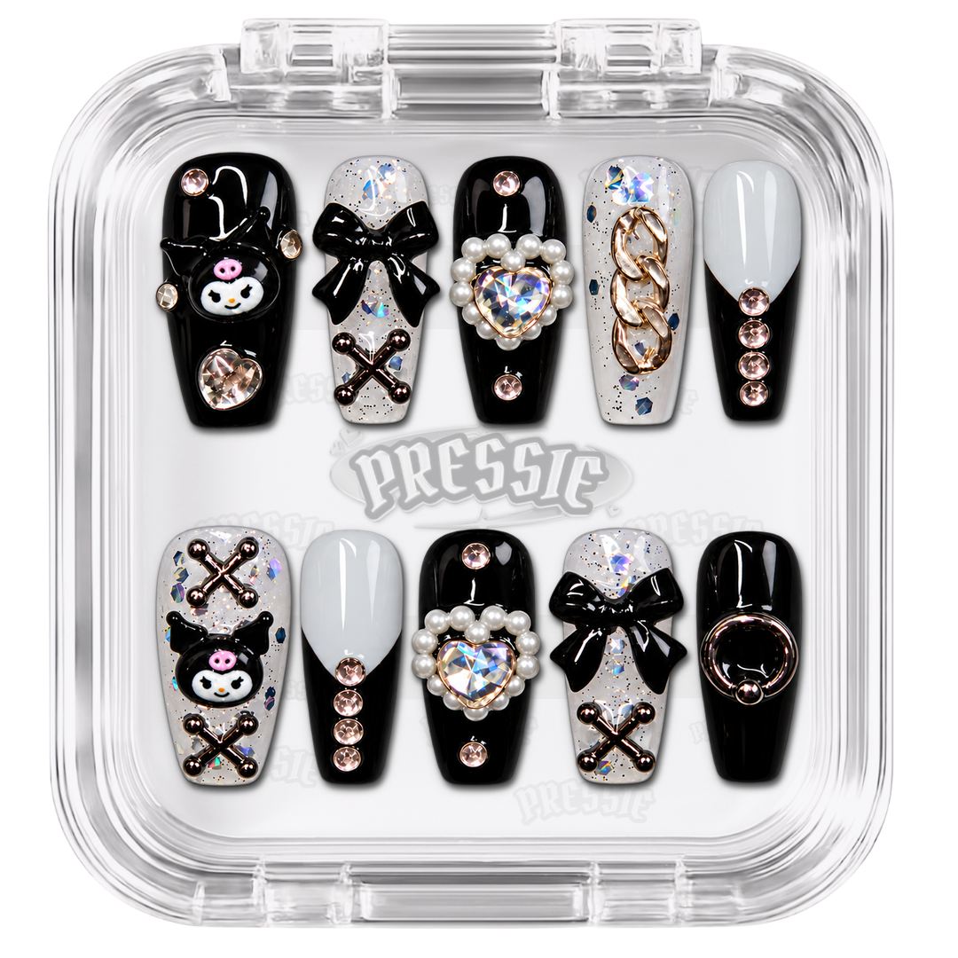 Faux ongles noirs et blancs à personnages kawaii, nœuds et perles, présentés dans leur boîte Pressie Nails — Winter. @product